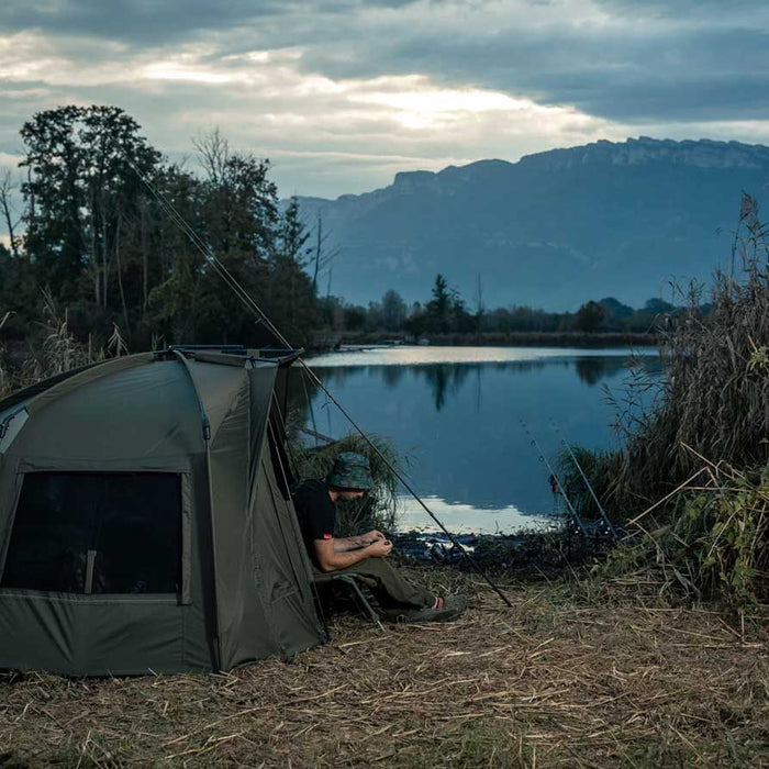 man in tent preparing for carp fishing