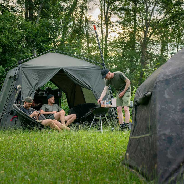 men sitting outside bivvy carp fishing